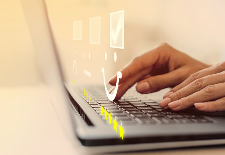 close up photo of someone using a laptop on a desk. Graphics of tick boxes and smiley and non-smiley faces have been overlaid