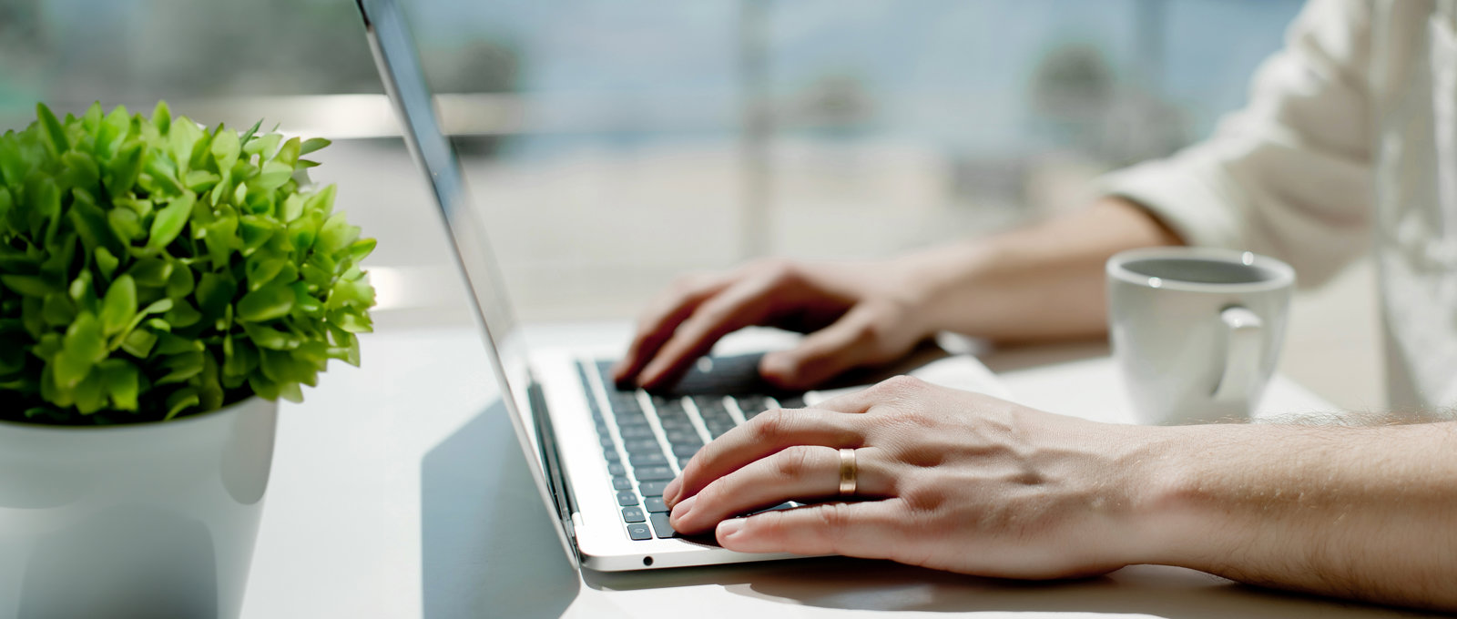 Close up photo of a woman typing on a laptop keyboard